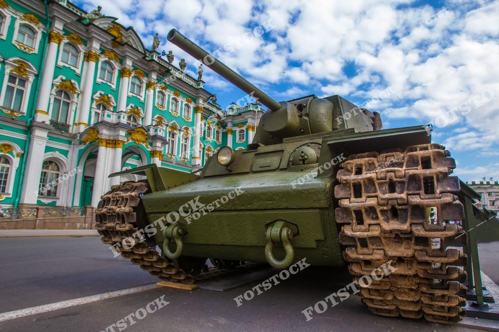 На фотографии изображён танк Т-34, установленный на Дворцовой площади Санкт-Петербурга, перед Зимним дворцом. Этот танк является символом победы в Великой Отечественной войне и напоминает о героическом прошлом страны. Зимний дворец, выполненный в стиле барокко, служит величественным фоном для экспозиции. Памятная композиция подчёркивает значимость исторических событий для Санкт-Петербурга.